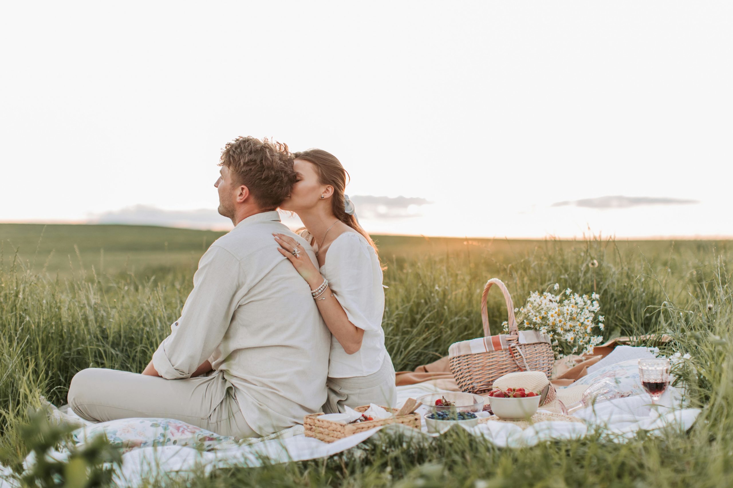 A Couple Having a Picnic on the Grass Field