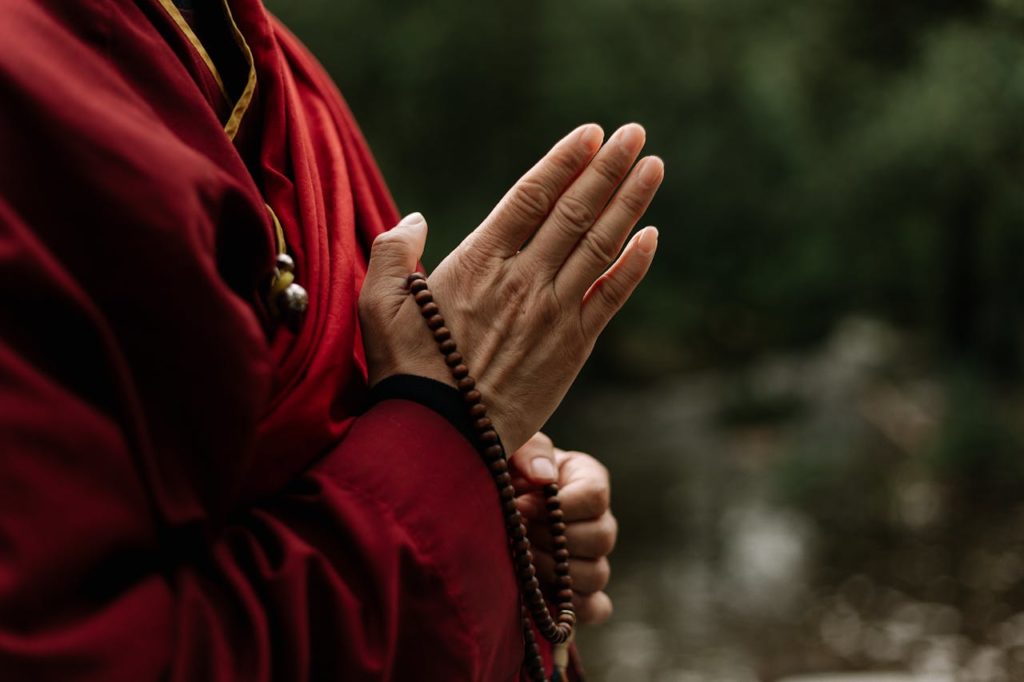 Hands Holding a Brown Prayer Beads