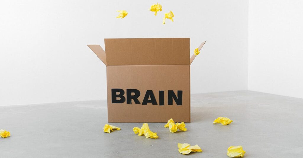 Crumpled yellow paper pieces on floor near carton box with Brain title on white background