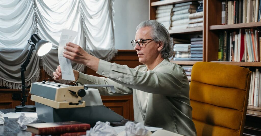 Senior man in a library sorting papers with a vintage typewriter.