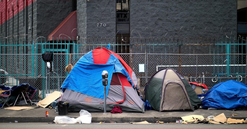 A view of tents set up on a sidewalk in Los Angeles, representing urban homelessness.