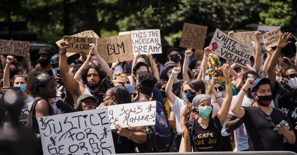 Protesters rally for justice and equality, displaying powerful signs in a city street.
